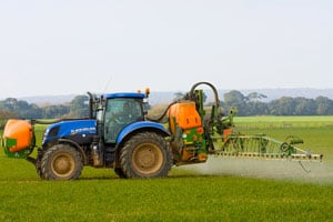Tractor spraying agricultural land