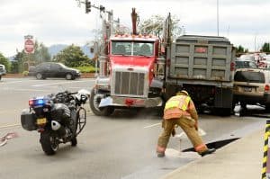 firefighters laying granular absorbent on a truck diesel spill