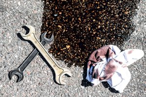 repair tools beside a rag and oily puddle