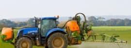 Tractor spraying agricultural land