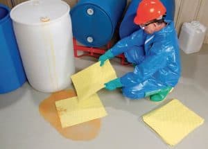 Applying yellow absorbent pads to clean up a chemical spill