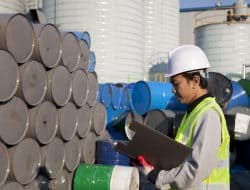 factory worker with chemical drums