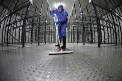 Worker cleaning empty storehouse floor