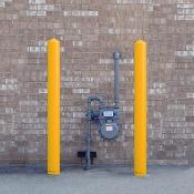 Yellow bollard covers protecting a meter device