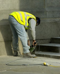 Construction worker using a concrete saw